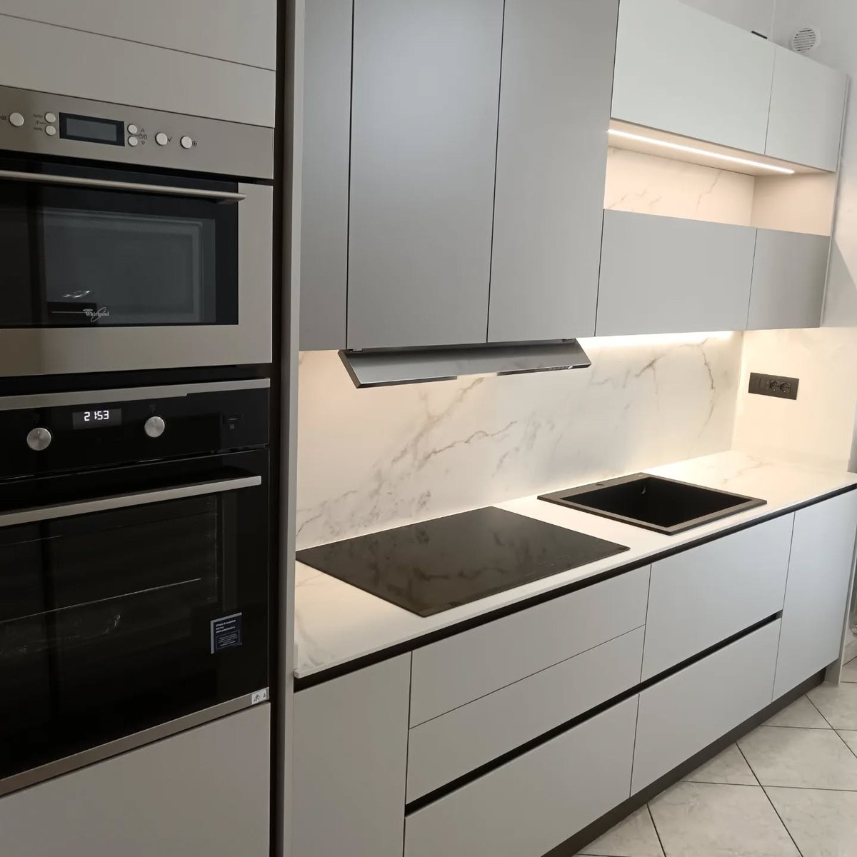 Cucina lineare con forni a incasso e piano effetto marmo progettata su misura a Pinerolo